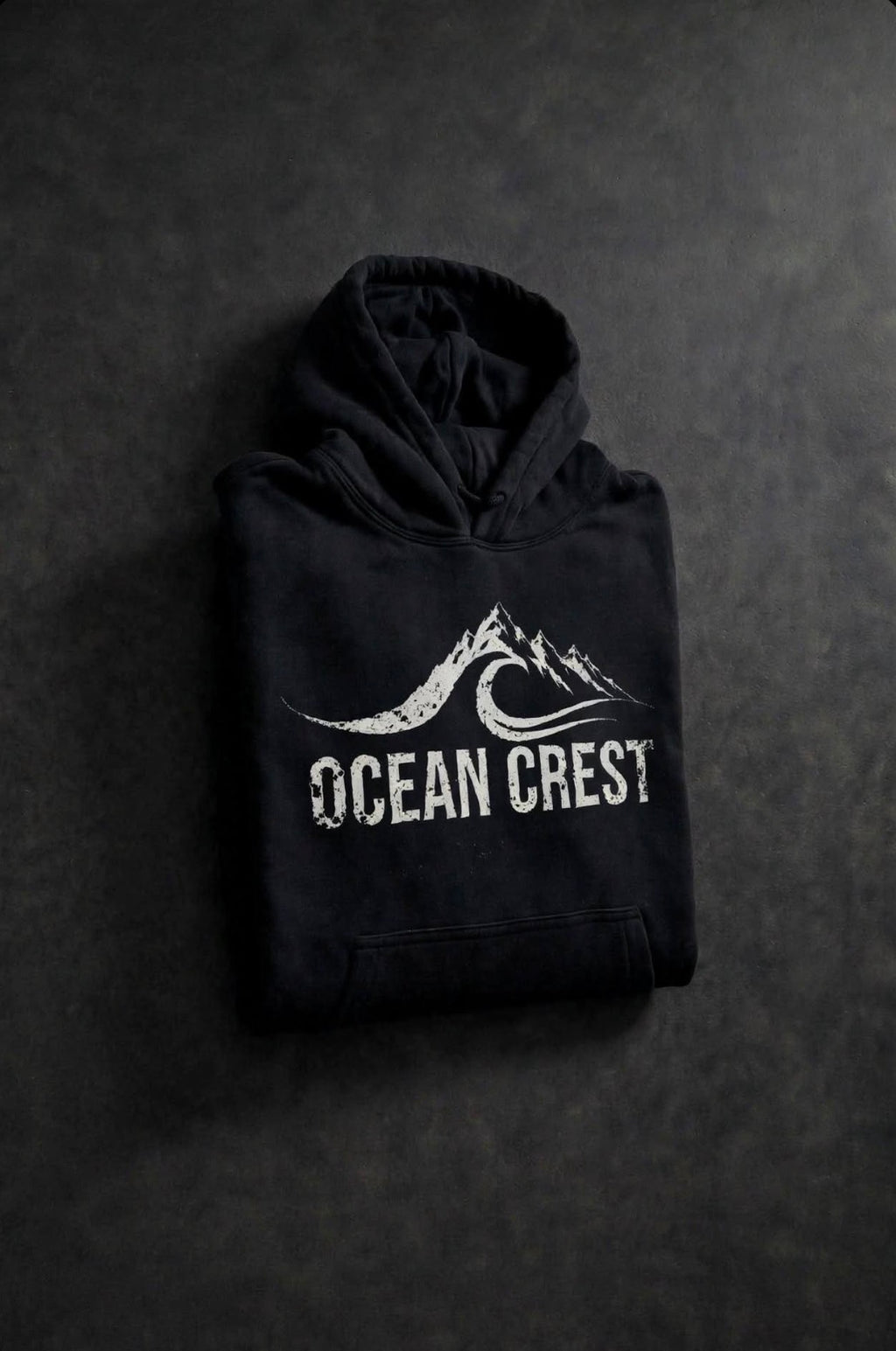 Folded black hoodie with white OCEAN CREST graphic.